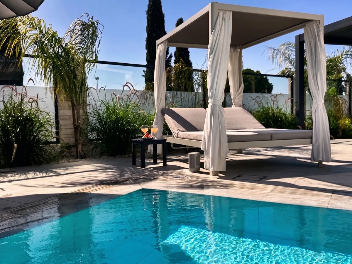 The pool and a shaded daybed at Villa Margarita
